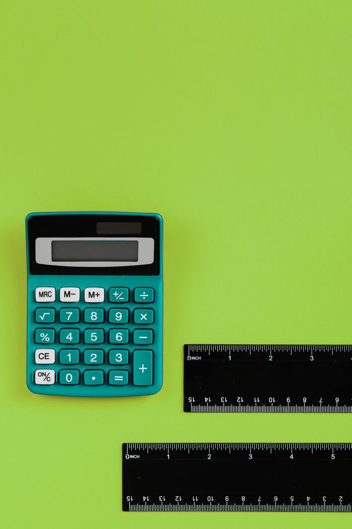 Calculator and rulers on a bright green surface, perfect for educational themes.
